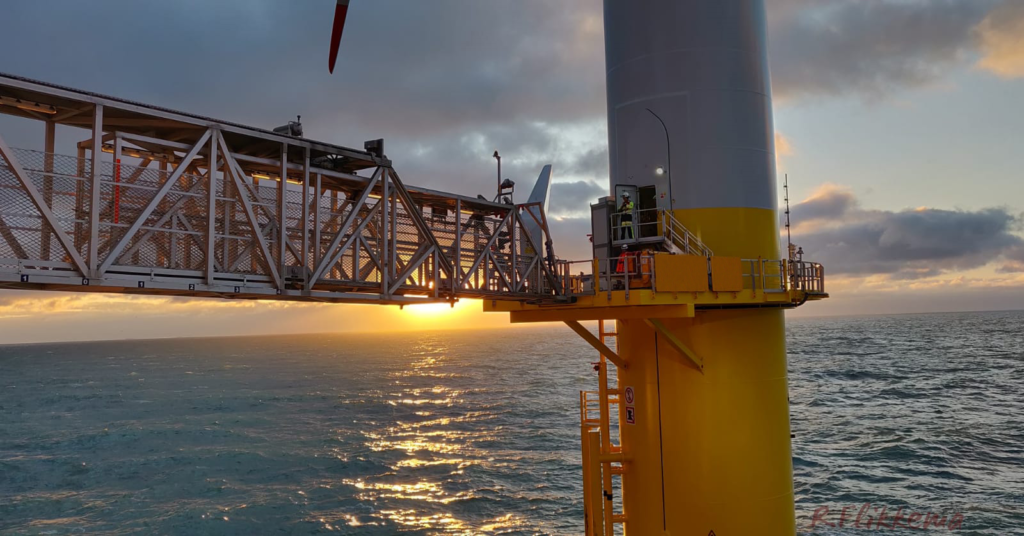 Norther offshore wind farm with sun behind Ampelmann